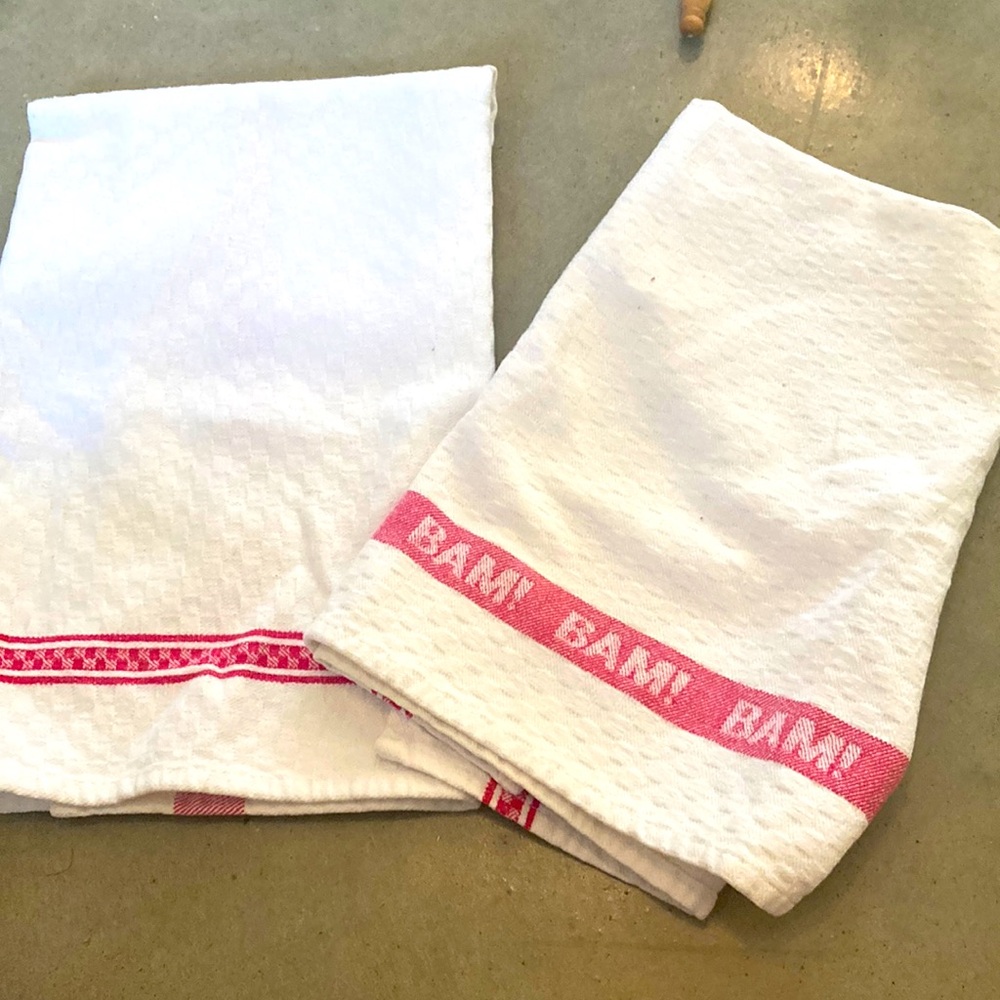 Emeril New Orleans cotton kitchen towels. White and red and white say BAM
